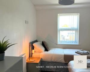 a small bedroom with a bed and a window at Ling Street - City Centre - Long stays - Contractors in Liverpool