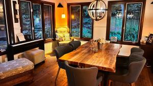 PETIT COIN DE PARADIS في Sainte Anne des Lacs: غرفة طعام مع طاولة وكراسي خشبية
