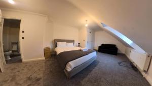 ein Schlafzimmer mit einem Bett in einem Zimmer im Dachgeschoss in der Unterkunft Large 6 bed house - 6 Bedrooms - Parking WIFI 6 smart TVs 3 shower rooms 4 WCs in Kettering