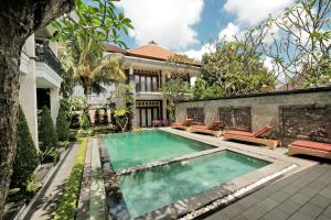 an image of a swimming pool in front of a house at Sumantra Guest House in Ubud