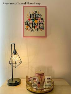 une lampe assise sur une table avec une photo sur le mur dans l'établissement Cosy Apartments Near Hampstead Heath With Free On-Site Parking & Private Gardens, Golders Green, à Londres