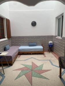 Maison vintage à louer sur deux étages في بركان: غرفة نوم بسريرين وسجادة نجمة