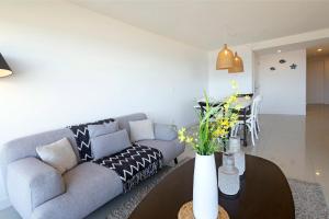 a living room with a couch and a table at Oceana Suites en Lumiere, frente a playa Mansa in Punta del Este