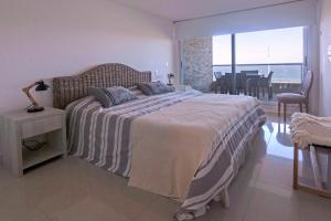 1 dormitorio con 1 cama grande y vistas al océano en Oceana Suites en Lumiere, frente a playa Mansa, en Punta del Este
