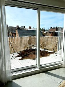 uma vista para uma varanda com uma mesa e cadeiras em Penthouse GuiZa em Namur