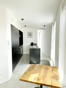 una cocina con mesa de madera en una habitación blanca en Penthouse GuiZa, en Namur