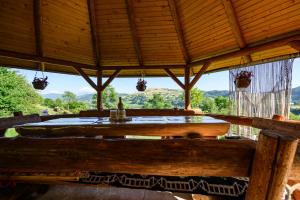 een groot houten paviljoen met een tafel en een raam bij Cabana din Revier in Vişeu de Jos