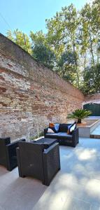 a patio with wicker furniture and a brick wall at Cozy Small Villa with Private Garden in Venice