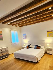 a bedroom with a large white bed and wooden ceilings at Cozy Small Villa with Private Garden in Venice