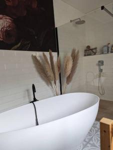 a white bath tub in a bathroom with feathers on the wall at Haus in der Nähe vom See in Markranstädt