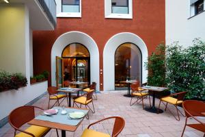 a patio with tables and chairs in front of a building at La Briosa in Bolzano