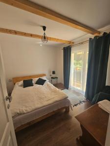 1 dormitorio con 1 cama con cortinas azules y ventana en Cabana Denis & Kevin en Petrila
