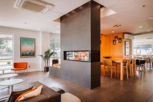 a living room with a fireplace and a dining room at Le Dauphin Montréal-Longueuil in Longueuil