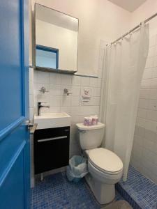 uma casa de banho com um WC, um lavatório e um espelho. em P0 - Walk To The Beach - 4br4br - 1113 Piccioni em San Juan