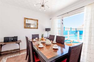 a dining room with a table and a large window at Villa Lory in Callao Salvaje