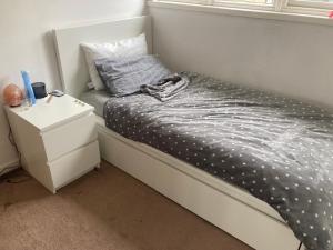 a small bedroom with a bed with a night stand at Lokiladdich in Bearsden