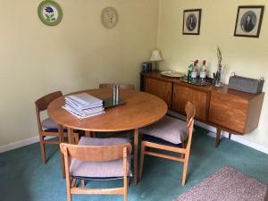 a dining room table with chairs and a desk at Lokiladdich in Bearsden