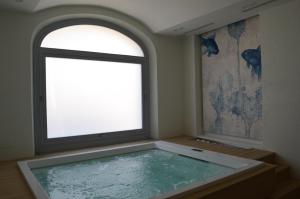 a large bath tub in a room with a window at TANIT ROOMS & SPA in Villasimius