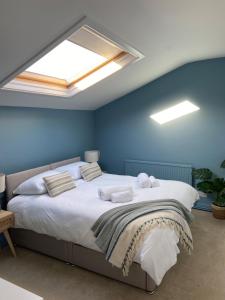 a bedroom with a large bed with a skylight at Seaglass Cottage Mumbles in Oystermouth