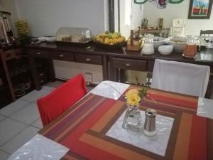uma cozinha com uma mesa com um vaso de flores em Petra Lodge em Edenvale