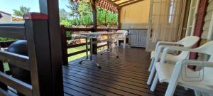 Massieuxにあるcoin de paradis bord de Saone (avec jacuzzi)の白い椅子とテーブル付きのポーチ