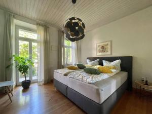 Un dormitorio con una cama con almohadas amarillas. en Cozy Rosy - gemütlich, zentral, frei Parken! en Bamberg