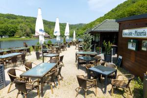 a group of tables and chairs in front of a restaurant at 5 Sterne Ferienhaus Annika mit Kamin, Seeblick und großer Terrasse in Rieden