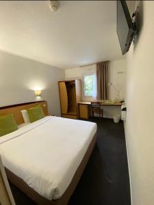 a hotel room with a large bed and a desk at Kyriad Le Blanc-Mesnil in Le Blanc-Mesnil