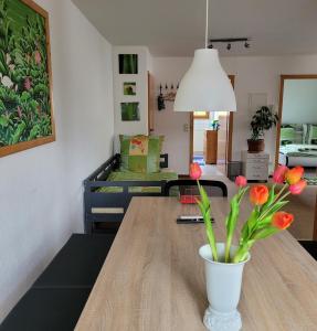 sala de estar con mesa y jarrón con flores en Ferienwohnung im Schwarzwaldhaus, en Behla