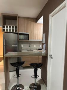a kitchen with a counter and two stools in it at VG FUN-OCEAN VIEW BEACH FRONT APARTMENT-Fortaleza in Fortaleza