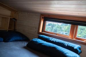 una camera da letto con due cuscini e una finestra in una cabina di Arboretum a Vlasenice