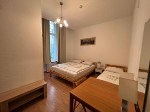 Habitación con 2 camas y mesa. en Hotel-Pension Spree, en Berlín