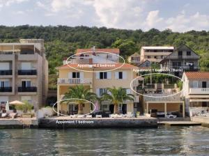 a group of buildings on the water next to a river at Villa Milovic, appartements les pieds dans l'eau! in Radovici
