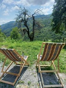 two chairs sitting on top of a hill with a view at Rusikos guest house in Oni