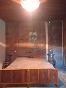 Cama en habitación con 2 sillas y luz en Rusikos guest house, en Oni