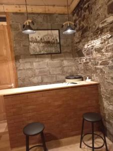 un bar con due sgabelli di fronte a un muro di mattoni di Rusikos guest house a Oni