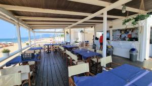 a restaurant with blue tables and chairs and the beach at VILLA CECILIA sul LAGO fronte MARE in Sperlonga