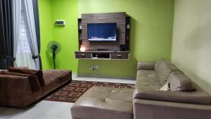 ein Wohnzimmer mit einem Sofa und einem Flachbild-TV in der Unterkunft Ct HOMESTAY in Changlun