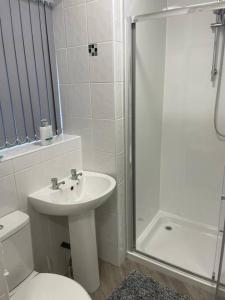 a bathroom with a toilet and a sink and a shower at Lovely 2 bedroom apartment in Fleetwood in Fleetwood