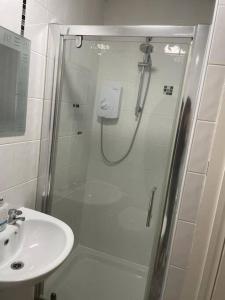 a shower with a glass door next to a sink at Lovely 2 bedroom apartment in Fleetwood in Fleetwood