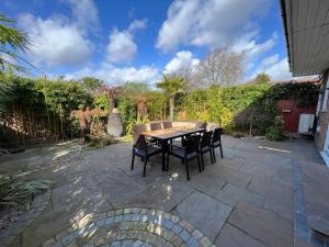 a wooden table and chairs on a patio at Luxury 4 bedroom house in Mill Hill in Mill Hill