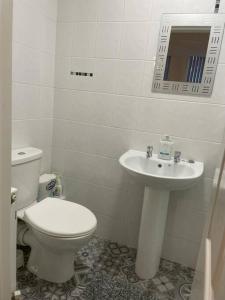 a white bathroom with a toilet and a sink at Lovely 2 bedroom apartment in Fleetwood in Fleetwood