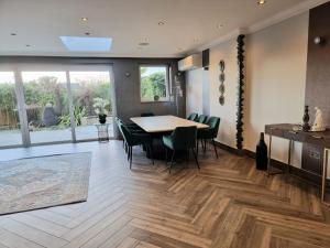 a dining room with a table and green chairs at Luxury 4 bedroom house in Mill Hill in Mill Hill