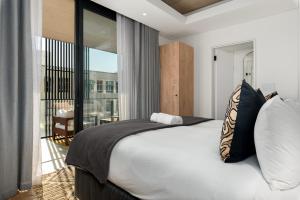 a bedroom with a large bed and a balcony at Station House Apartments in Cape Town