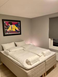 uma cama num quarto com uma fotografia na parede em Modern 2 bedroom apartment in Oslo city centre em Oslo