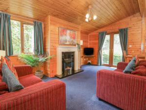 uma sala de estar com dois sofás vermelhos e uma lareira em Elm Lodge em Keswick
