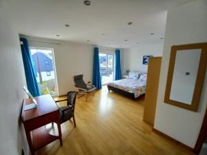 a bedroom with a bed and a desk and a chair at Cellar Cove in Perranporth