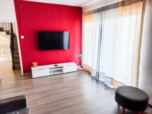 a living room with a red wall with a flat screen tv at Residential House 3 Bedroom, 1 Bathroom Entire unit in Beau Bassin in Beau Bassin