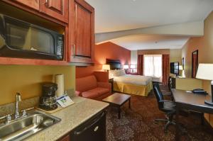 a hotel room with a bed and a kitchen at Holiday Inn Express Hotel and Suites Altus, an IHG Hotel in Altus