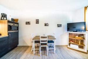 cocina con mesa con sillas y TV en Fewo Janks I 11A-N1 I Zentrales Apartment, en Witzenhausen